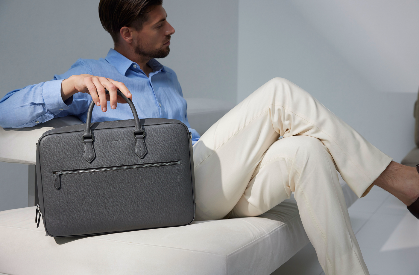 Moderner Geschäftsmann im Büro, ausgestattet mit einer stilvollen Aktentasche aus Leder.